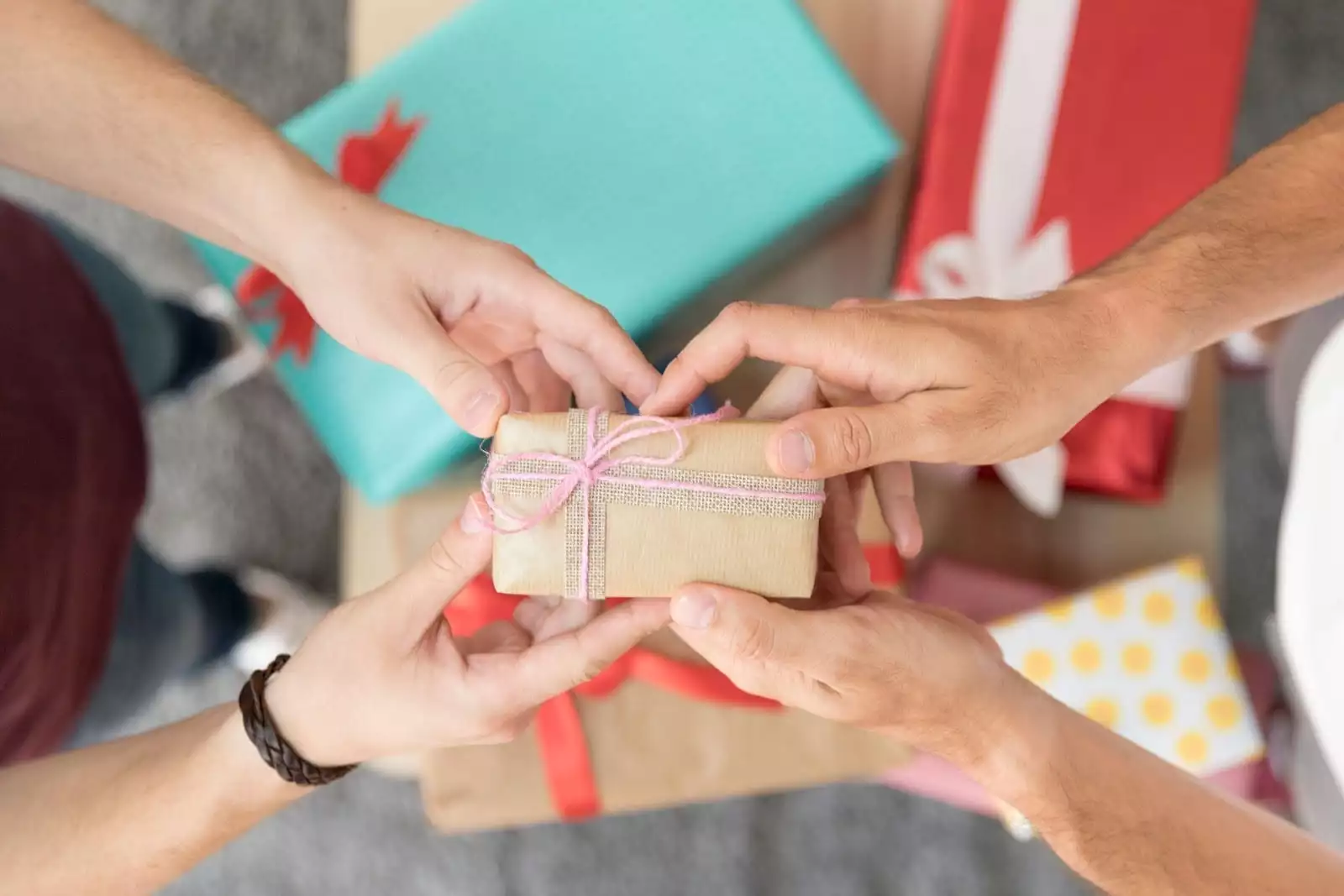One pair of hands passes a wrapped gift to another