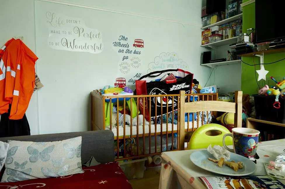 9 month old Adam sleeps with mum Emily and dad Martin in the living room. With sister Patricia, 10, brothers Bradley 6 and Harry 3, the family of six also eat here as there is nowhere to sit