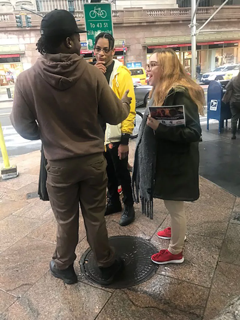 Two canvassers speak to a man: notice the number 43 in the background on the sign.