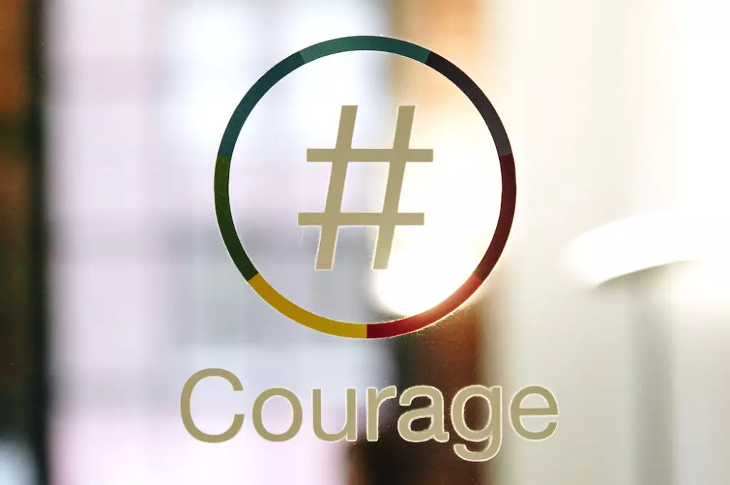 Nationbuilder logo with 'courage' underneath on a glass door