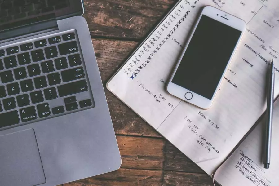 Laptop, phone and notebook on a desk