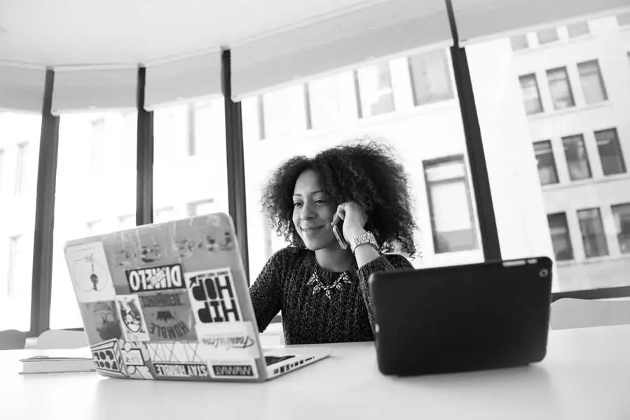 Happy woman sitting at a desk with a laptop