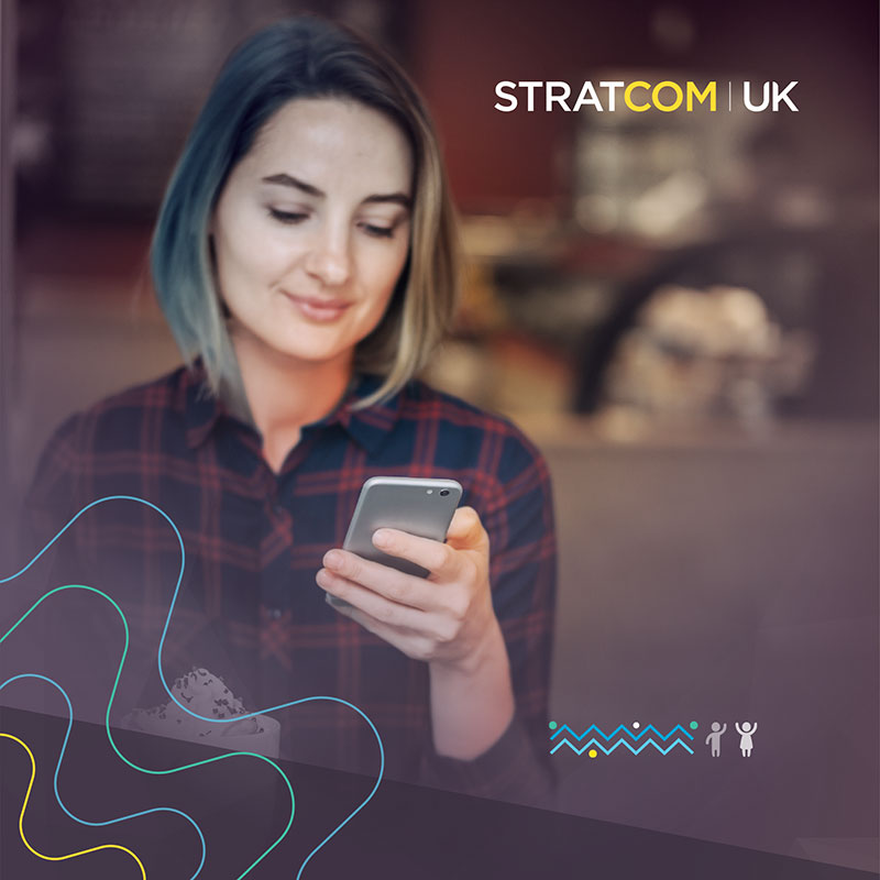 A woman donor giving to charity on a mobile phone using Stratcom's SMS service