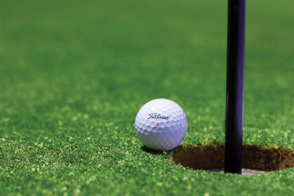 A golf ball next to a hole. By Pexels from Pixabay