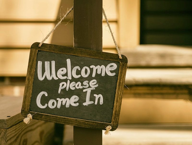 Sign saying 'welcome please come in'. Image: Unsplash.com