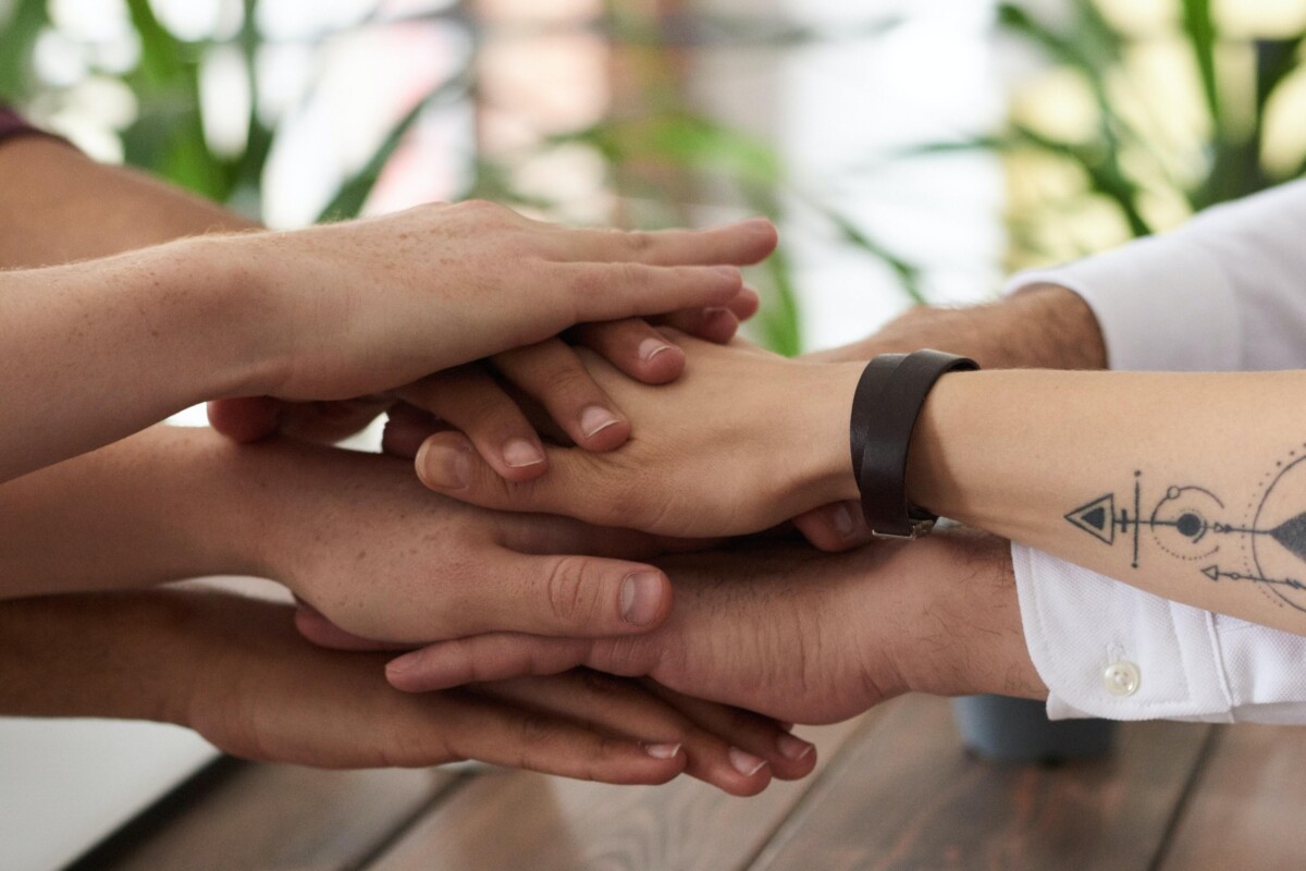 A stack of hands on top of each other. By Fauxels on Pexels