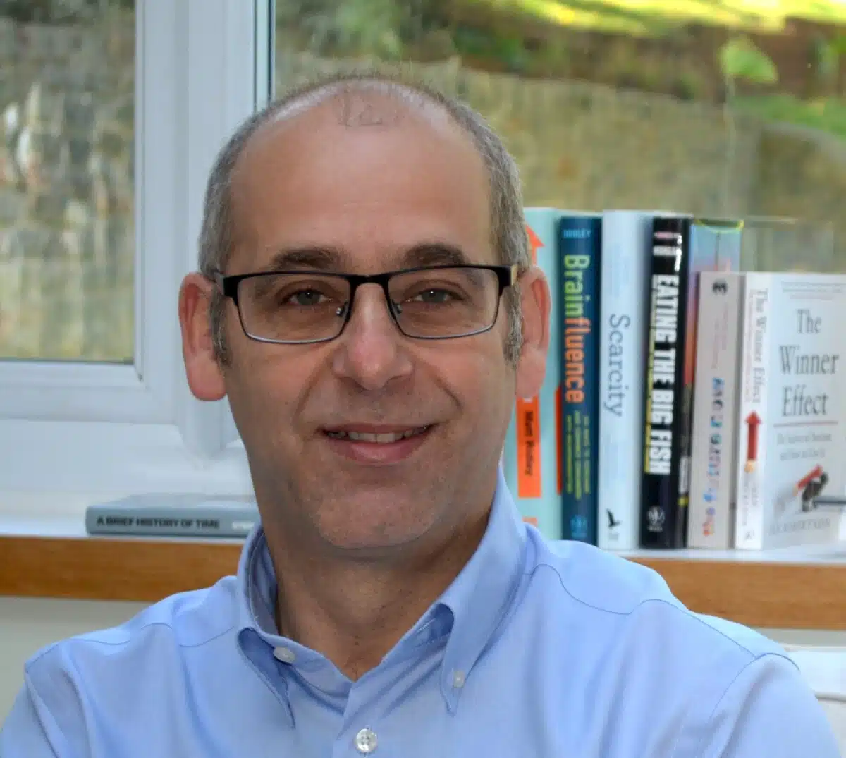 Allan Freeman, with bookshelf and garden behind him