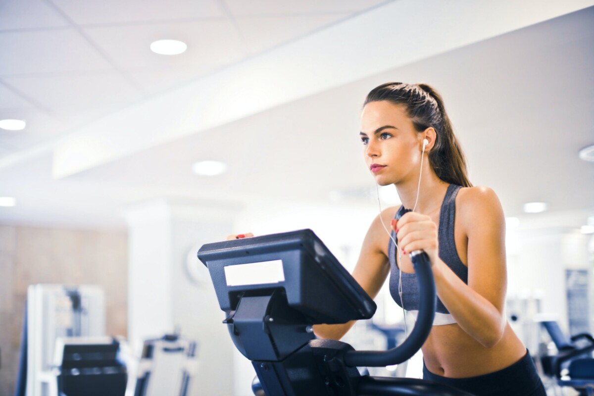 A woman uses an exercise machine at a gym.