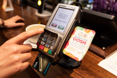 Hands holding a card payment terminal showing an on-screen donation prompt for Great Ormond Street Hospital Charity.