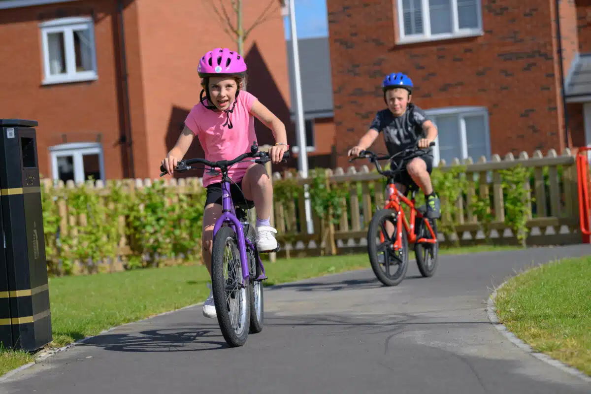 Children cycling outside Persimmon homes.