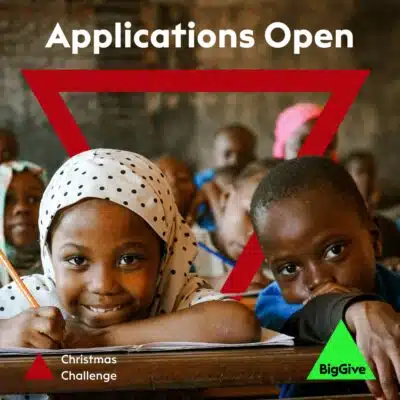 Big Give 2025 applications open now. Image of two schoolchildren smiling, plus the Big Give triangle logo.