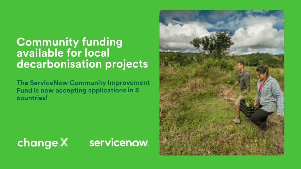 Community funding available for local decarbonisation projects. Logos of ChangeX and ServiceNow. Photo to the right of two people carrying a heavy box of equipment outdoors in a rural setting.