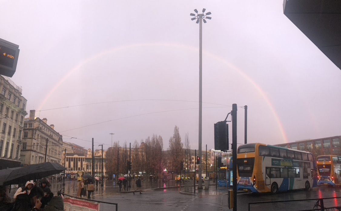 Piccadilly Gardens, Manchester in the rain, with a rainbow.