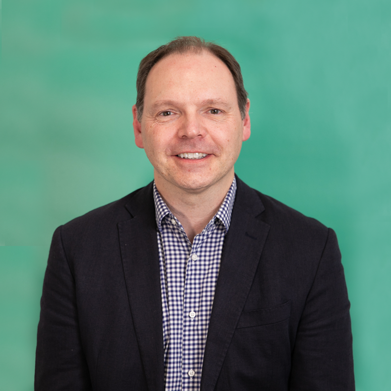 Richard Nightingale, in front of a green wall or background